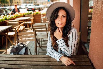 beautiful happy young girl in a hat resting outdoors, woman in cafe