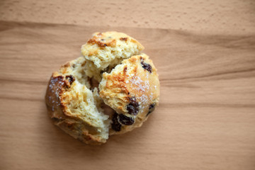 Bun with raisins on a wooden table.