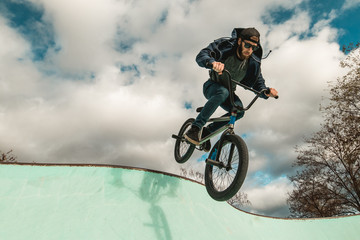 Fototapeta na wymiar Boy riding and jumping bmx bike in a park.Extreme sports