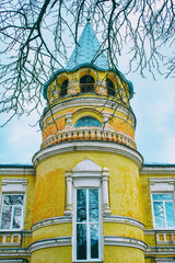 Photo of old retro building behind a small park alley with benches