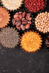 Various superfoods in small bowl on black background