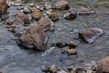 water of stream flowing around boulders and stones