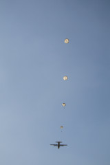 Airplane and paratroopers with parachutes in the sky .Military parachute jumper in the sky.