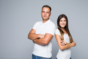 Portrait of couple standing back to back and looking at camera over gray wall