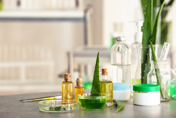 Cosmetic products with aloe on table in laboratory