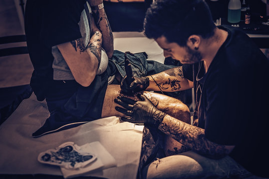 Tatuatore che Tatua coscia