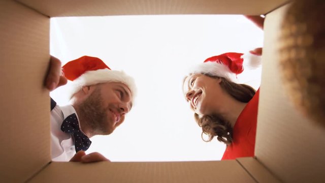 people and holidays concept - happy couple opening christmas gift box