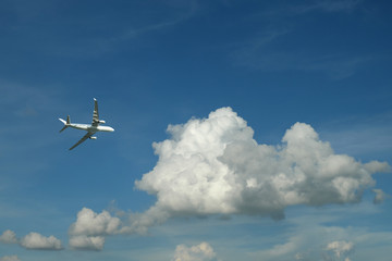 Airplane flying in blue sky and clouds