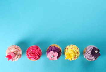 Delicious cupcakes on color background