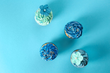 Delicious cupcakes on color background