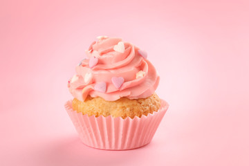 Tasty cupcake on color background