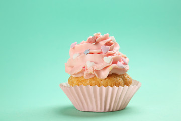 Tasty cupcake on color background