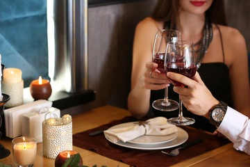 Loving couple with glasses of wine in restaurant on romantic date