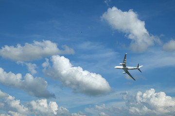 Airplane flying in blue sky and clouds