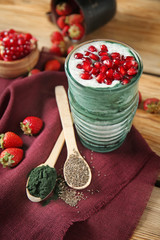 Glass of spirulina smoothie on wooden table