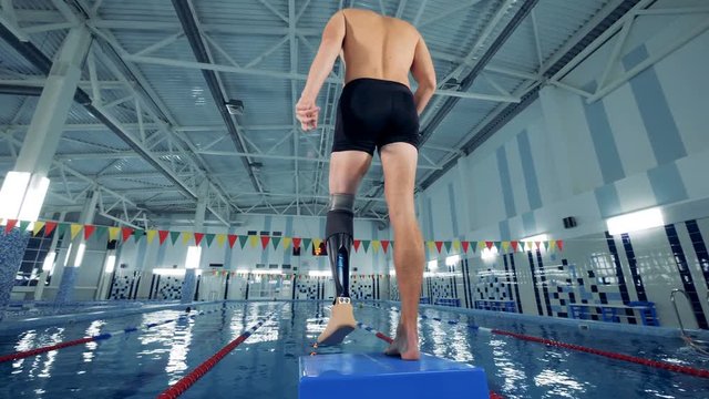 A man with a bionic leg is warming up in a swimming pool