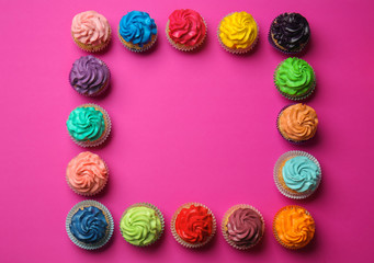 Frame made with different cupcakes on color background