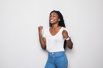 Portrait of a happy young african woman celebrating success isolated over gray background