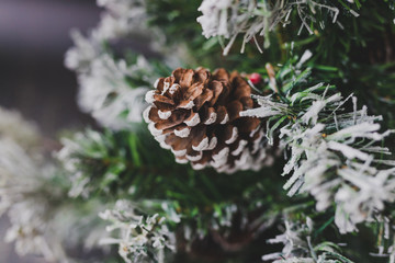 Naklejka na ściany i meble detail of small Christmas tree with snow mistletoe and pine cone decorations,