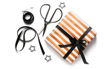 Beautiful gift box with scissors and ribbon on white background