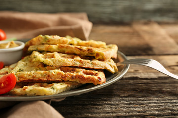 Metal tray with tasty squash waffles and sauce on wooden table