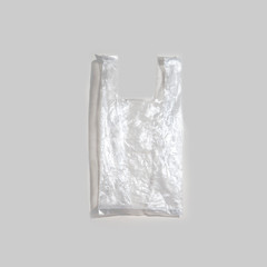 Shopping Handle Disposable Plastic Bag Package On a grey background . Say no to plastic bags . eco activist holding a globe. Ecology conversation Concept .