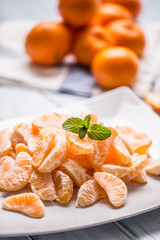 Fresh pieces of tangerines mandarin on the plate or in a bowl