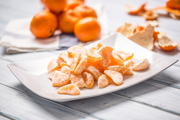 Fresh pieces of tangerines mandarin on the plate or in a bowl