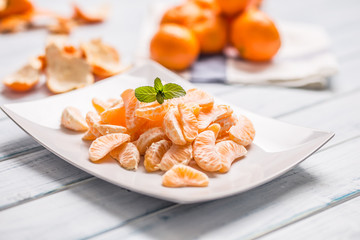 Fresh pieces of tangerines mandarin on the plate or in a bowl