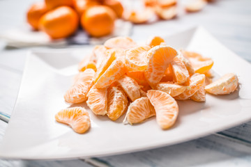 Fresh pieces of tangerines mandarin on the plate or in a bowl
