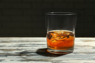 Glass of whiskey on wooden table