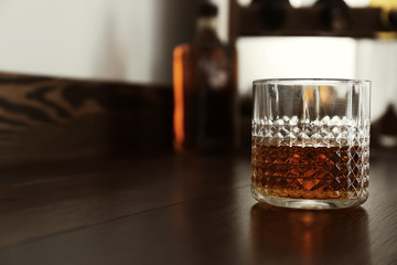 Glass of whiskey on wooden table