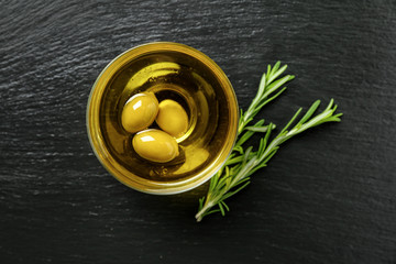 Bowl of fresh olive oil on dark table