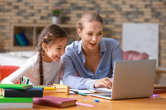 Cute Girl With Mother Doing Homework At Home