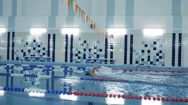 Indoors swimming pool and a man with a bionic leg swimming along it