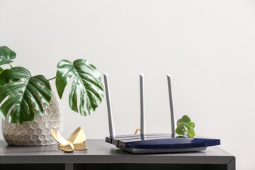 Modern wi-fi router on dark table - obrazy, fototapety, plakaty