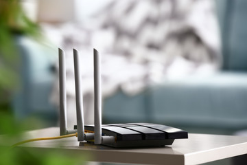 Modern wi-fi router on light table in room - obrazy, fototapety, plakaty