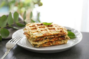 Plate with tasty squash waffles on grey table