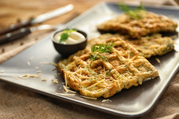 Tasty squash waffles with sauce on plate, closeup