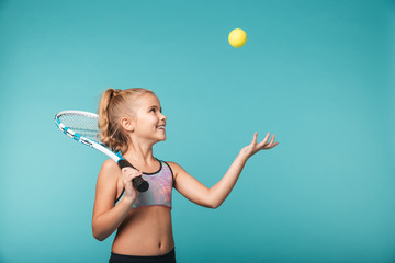 Cheerful young sports girl playing tennis
