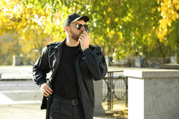 Male security guard with portable radio transmitter outdoors
