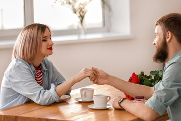 Loving young couple during romantic date in cafe