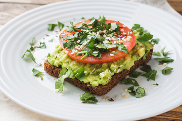 Avocado toast. Healthy toast with avocado mash and tomatoes on a plate.
