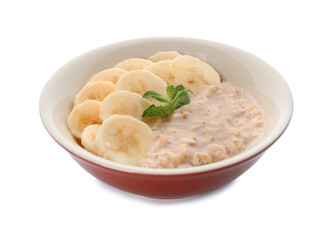 Tasty oatmeal with banana slices in bowl on white background