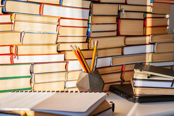 Open book, textbook, laptop, pencils in library, stack piles of literature text archive,...