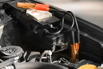 Battery charger under open hood of car