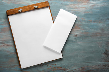 Clipboard with empty sheets of paper on wooden table - obrazy, fototapety, plakaty