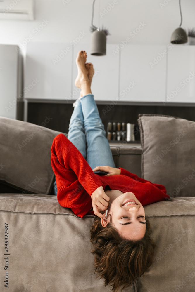 Wall mural Cheerful young woman relaxing at home