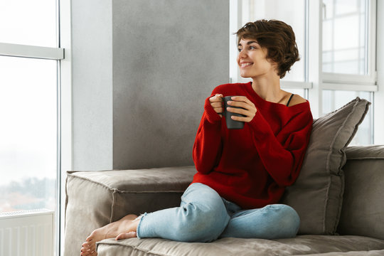 Smiling young woman wearing sweater relaxing