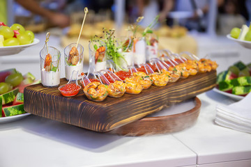 Cocktail Reception at the event, with dry ice Shrimps, burgers, salads, seafood on wooden boards, with sprouted greens